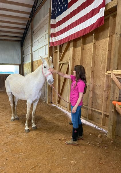 Amy Thompson with one of the horses in the Holos Hope program.